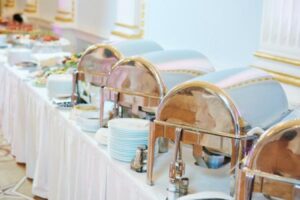 A buffet is set up on a table with a white tablecloth